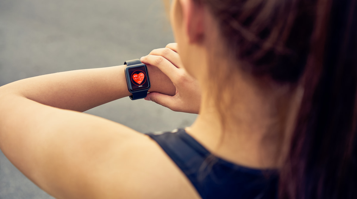 Woman checking heart rate on watch for atrial fibrillation exercise symptoms